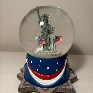 Statue of Liberty Snow Globe with American Flags by Hallmark. Water is clear.
